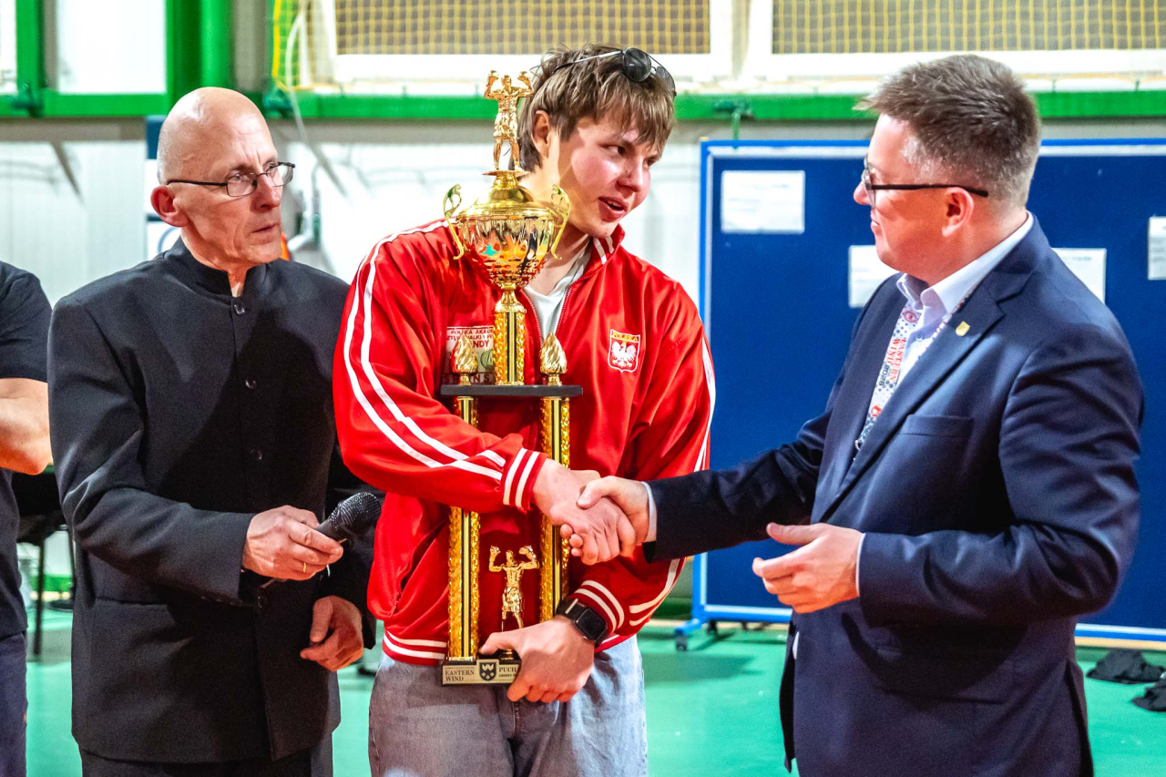 Wójt Gminy Perlejewo Jakub Wierzbicki i Andrzej Nowaczuk wręczają zawodnikowi Puchar Wójta podczas turnieju Eastern Wind w Perlejewie.