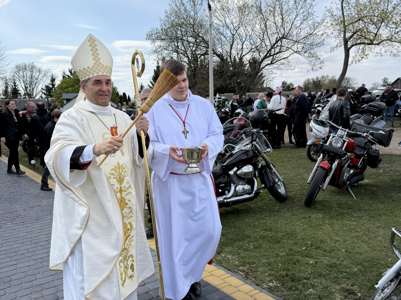 Motocykliści, mieszkańcy i duchowni pozują do wspólnego zdjęcia przed kościołem w Grannem z bp. Piotrem Sawczukiem